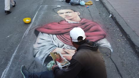 Static-Shot-Of-Street-Artist-Drawing-A-Pastel-Of-Frida-Kahlo-In-Bogota-Colombia