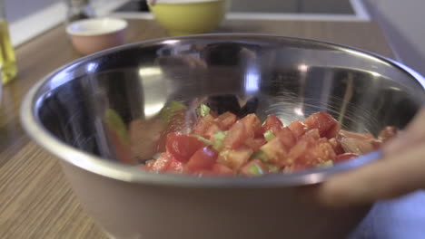 Mezclando-Verduras,-Tomates-Y-Paprika-Con-Cebollas-En-La-Cocina,-Preparando-Una-Comida,-Toma-De-Ensalada-A-Cámara-Lenta