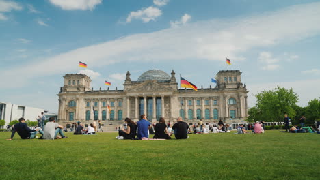 Tourists-And-Locals-Rest-On-The-Lawn-Near-The-Bundestag-In-Berlin-01