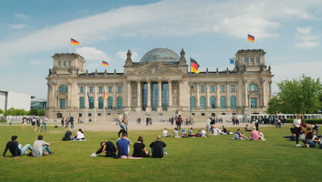 Tourists-And-Locals-Rest-On-The-Lawn-Near-The-Bundestag-In-Berlin-02