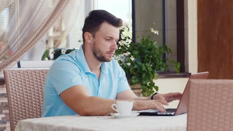 Man-Drinks-Coffee-And-Uses-A-Laptop