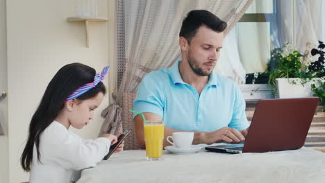 Man-Uses-Laptop-As-Daughter-Uses-Smartphone