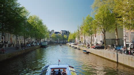 Tour-Boat-Sailing-On-Canal-In-Amsterdam