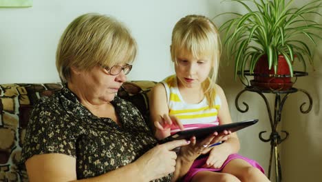 Grandma-And-Granddaughter-Using-Tablet-Together-01