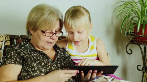 A-Young-Girl-With-A-Grandmother-Using-Tablet