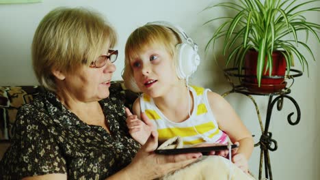 Grandma-And-Granddaughter-Using-Tablet-Together-02