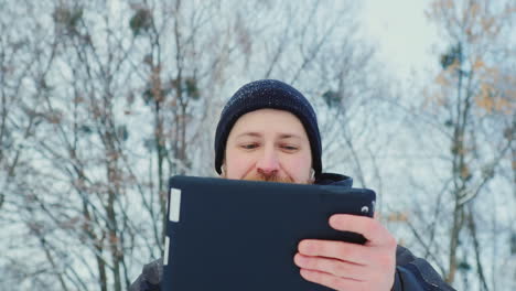 Smiling-Man-Uses-Tablet-In-Winter-Park-02