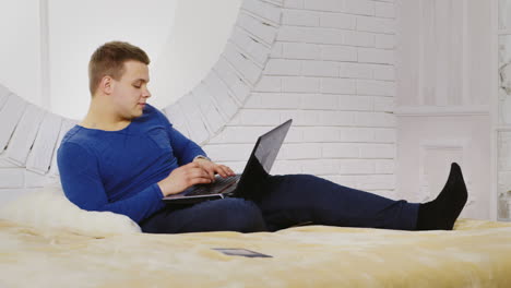 Young-Man-Casually-Using-a-Laptop