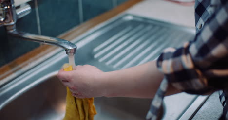 Close-Up-Of-Woman-Washing-Napkin-With-Water-At-Sink-In-Kitchen