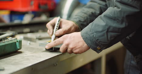 Man-Working-At-Metal-Industry-Cutting-And-Measuring-Metal-Parts-At-Workshop-4