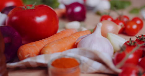 Nahaufnahme-Von-Verschiedenen-Gemüsesorten-Auf-Dem-Tisch,-Die-Frische-Tomaten,-Karotten,-Rote-Zwiebeln-Und-Knoblauch-Drehen?