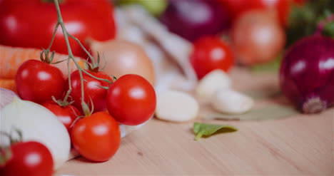 Cerca-De-Varios-Vegetales-En-La-Mesa-Giratoria-Tomates-Cherry-Frescos-Zanahoria-Cebolla-Roja-Y-Ajo-1