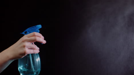 Close-Up-Of-Hand-Using-Sprinkler-And-Spraying-Water-On-Black-Background-1