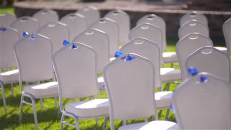 Panning-Shot-Of-Empty-White-Chairs-In-Lawn-At-Wedding-Ceremony