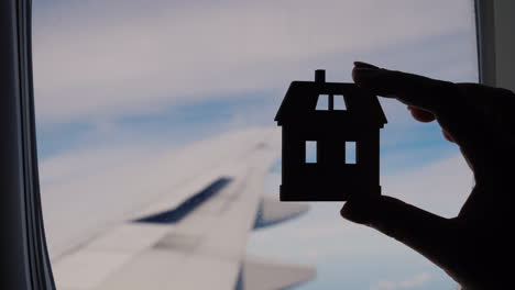 House-Figurine-Silhouette-in-Aeroplane-Window