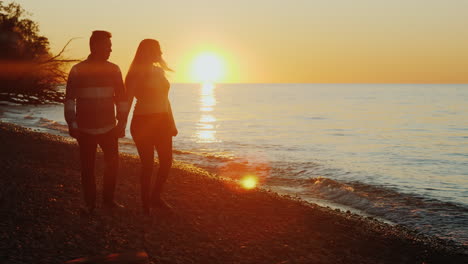 Couple-Walking-on-Beach-at-Sunset