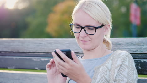 Woman-Using-Smartphone-on-a-Bench