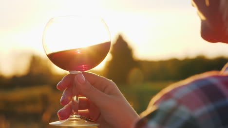Woman-Holds-Red-Wine-at-Sunset
