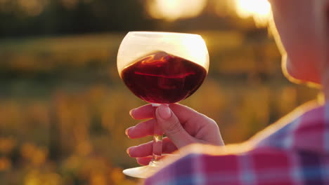 Woman-Holds-Red-Wine-by-Setting-Sun