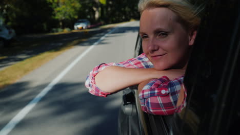Woman-Leans-Out-of-Car-Window