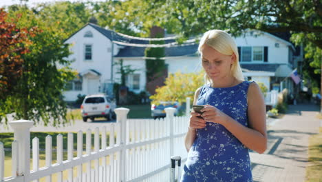 Woman-Using-Smartphone-on-Suburban-Street