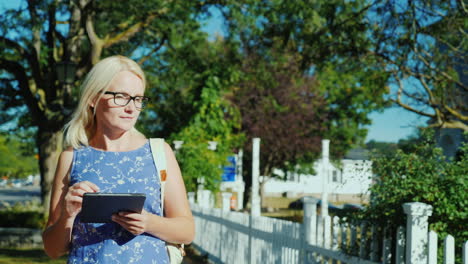 Woman-With-Tablet-on-Suburban-Street