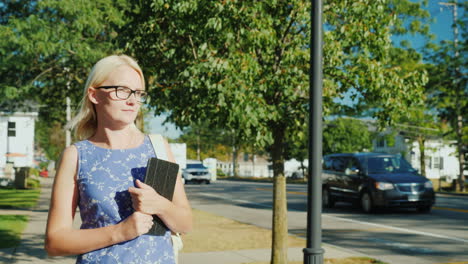 Woman-Walks-Through-Suburb-With-Tablet