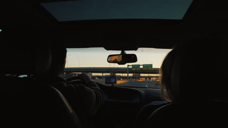 Couple-Driving-Car-at-Sunset