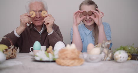Senior-Man-Smiling-Chererful-Grandfather-And-Granddaughter-Playing-With-Cakes-And-Smile-