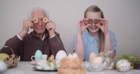 älterer-Mann-Lächelnd-Fröhlicher-Großvater-Und-Enkelin,-Die-Mit-Kuchen-Spielen-Und-Lächeln-1