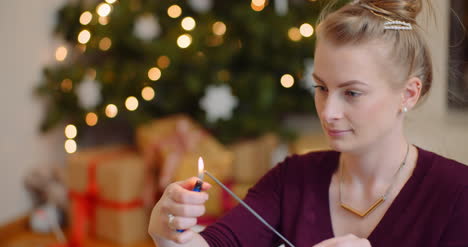 Young-Woman-Igniting-Sparkler-With-Lighter-At-Home