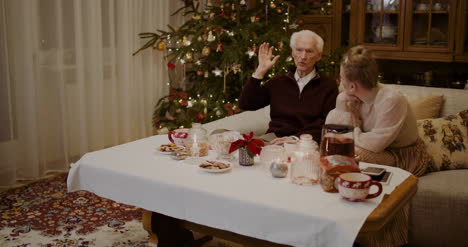 Woman-Listening-To-Grandfather-At-Home-During-Christmas-1