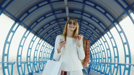 Eine-Stilvolle-Frau-Kommt-Mit-Einkaufstaschen-und-Telefoniert-Erfolgreiches-Einkaufskonzept