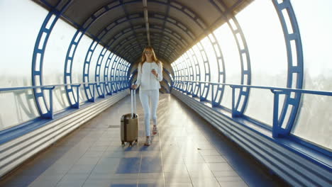Steadicam-Shot-Life-In-Motion-Stylish-Woman-With-Travel-Bag-Is-On-The-Sunlit-Move-Between-Terminals