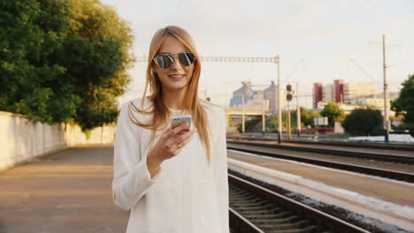 Portrait-Of-Successful-Business-Woman-On-A-Trip-He-Talks-On-The-Phone-At-The-Railway-Station