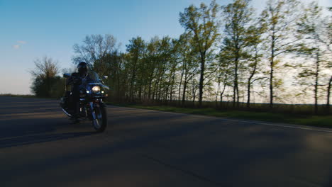 Biker-On-A-Motorcycle-Through-The-Trees-The-Sun-Shines