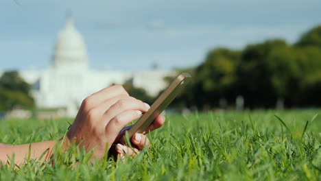 Woman's-Hands-Use-Phone-By-Capitol-Building