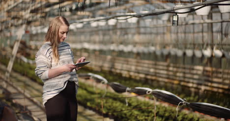 Female-Gardener-Using-Digital-Tablet-In-Greenhouse-7