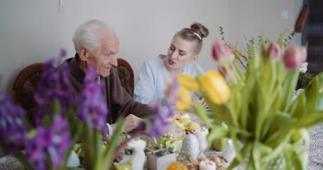 Happy-Easter-Senior-Man-And-Young-Woman-Conversating-During-Easter-Holidays