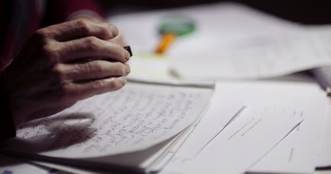 Closeup-Of-Businessman-Writing-On-Paper-At-Table-In-Office