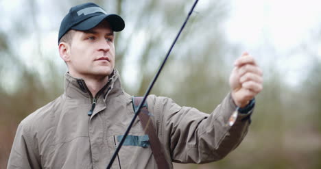 Confident-Man-Preparing-Fishing-Rod-At-Lakeshore-2