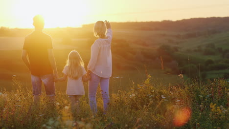 Young-Family-Of-Three-People-Enjoying-The-Sunset-On-A-Cliff