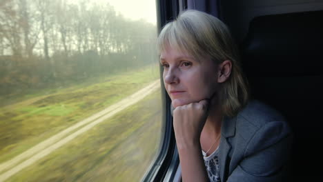 Young-Woman-Travels-By-Train-Looks-Out-The-Window-At-Beautiful-Scenery-Dreams-Slow-Motoin-Video