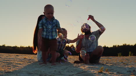 Parents-Play-With-Two-Boys-At-Sunset---Blow-Bubbles