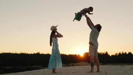 Young-Happy-Family-Playing-With-His-Son-At-Sunset-Father-Tossing-Baby