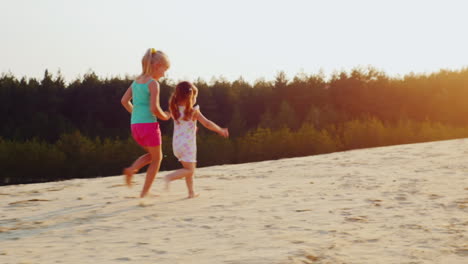 Two-Cheerful-Girl-Running-A-Race-On-The-Sand-At-Sunset-Children's-Games-A-Happy-Childhood-Prores-Hq-