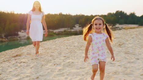 Happy-Childhood-Mother-Playing-With-Her-Daughter-On-The-Beach-Girl-Laughs-And-Runs-Away-From-His-Mot