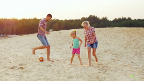 Families-With-A-Child-Playing-Football-In-The-Sand-On-The-Beach