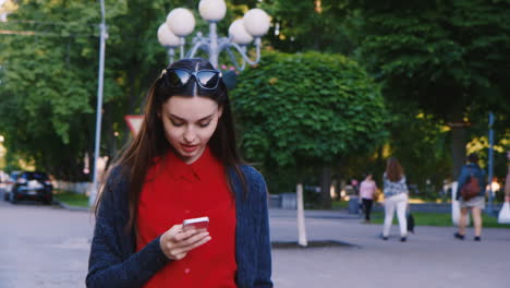 Attractive-Woman-Walking-Down-The-Street-Enjoying-The-Smartphone-Is-Typing-Looks-Posts