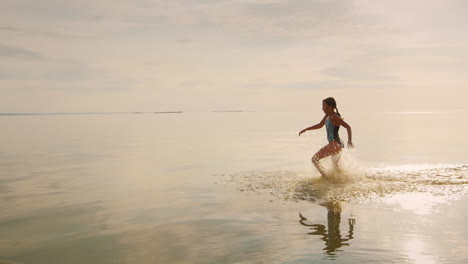 Carefree-Girl-Of-7-Years-Running-On-The-Water-From-Her-Feet-Flying-A-Lot-Of-Splashing-Slow-Motion